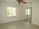 Bright bedroom with a ceiling fan, mirrored closet doors, and tile floors at 409 Ricold Ter, Port Charlotte, FL 33954