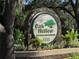 An ornate stone sign shows off the Oak Hollow Recreation Center, surrounded by lush landscaping at 409 Ricold Ter, Port Charlotte, FL 33954