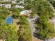 Aerial view of community featuring a pool, tennis courts, clubhouse, and parking surrounded by trees at 478 Winwood Ct, Port Charlotte, FL 33954