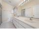Bathroom featuring dual sinks, a large mirror, and a walk-in shower at 478 Winwood Ct, Port Charlotte, FL 33954
