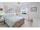 Cozy bedroom features a beach-themed bed, a ceiling fan, and a sunny window at 478 Winwood Ct, Port Charlotte, FL 33954