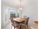 Sunlit dining room showcases a wood table, six chairs, and a bay window at 478 Winwood Ct, Port Charlotte, FL 33954