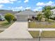 Well-maintained home featuring lush landscaping and a long driveway at 478 Winwood Ct, Port Charlotte, FL 33954