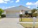 Charming single-story home with a well-maintained lawn, gray roof, and a two-car garage on a sunny day at 478 Winwood Ct, Port Charlotte, FL 33954