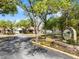 The entrance to the Oak Hollow Recreation Center features lush trees, manicured landscaping, and a paved driveway at 478 Winwood Ct, Port Charlotte, FL 33954
