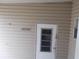 Back door with window and tan siding at 5421 Holiday Park Blvd, North Port, FL 34287