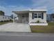 Charming home featuring a covered carport, decorative accents, and a well-maintained lawn at 5421 Holiday Park Blvd, North Port, FL 34287