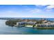Scenic aerial view of waterfront condos with a pool, docks, and the Gulf of Mexico in the distance at 600 Sutton Pl # 101B, Longboat Key, FL 34228