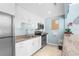 Modern kitchen features white cabinets, stainless steel appliances, granite countertops and a tile backsplash at 600 Sutton Pl # 101B, Longboat Key, FL 34228