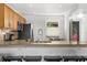 Kitchen featuring a granite countertop bar with stools, updated appliances, and wood cabinets at 600 Sutton Pl # 101B, Longboat Key, FL 34228