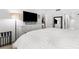 Bright main bedroom featuring white furniture, a large television, and ensuite bath access at 600 Sutton Pl # 101B, Longboat Key, FL 34228