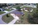Aerial view of a home with solar panels, a well-manicured lawn, and a paved driveway at 7882 Dulce Ave, North Port, FL 34287