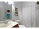 Cozy bathroom features a white floral shower curtain, and brown vanity at 7882 Dulce Ave, North Port, FL 34287