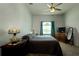 Cozy bedroom with ceiling fan, dresser with television, and natural light from the window at 7882 Dulce Ave, North Port, FL 34287