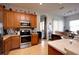 Well-lit kitchen with stainless steel appliances, tan countertops and wood cabinets at 7882 Dulce Ave, North Port, FL 34287