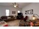 Cozy living room featuring a ceiling fan, leather furniture, and neutral carpet at 7882 Dulce Ave, North Port, FL 34287