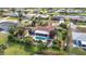 Aerial view of house with pool, lush gardens and screened-in lanai in a waterfront community at 82 Caddy Rd, Rotonda West, FL 33947