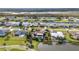 Expansive aerial view of neighborhood homes, a canal, and manicured lawns, many with private pools at 82 Caddy Rd, Rotonda West, FL 33947
