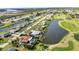 Aerial view showing canal front neighborhood with lush landscaping and a golf course at 82 Caddy Rd, Rotonda West, FL 33947