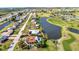 This aerial view captures a single-Gathering home near a golf course and pond, showcasing neighborhood streets at 82 Caddy Rd, Rotonda West, FL 33947