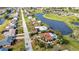 This aerial view captures a single-Gathering home near a golf course and pond, showcasing neighborhood streets at 82 Caddy Rd, Rotonda West, FL 33947