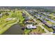 Aesthetic aerial view of golf course, canals, and residences, creating a serene neighborhood ambiance at 82 Caddy Rd, Rotonda West, FL 33947