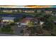 Stunning aerial view of a charming home with lush landscaping, pond, and nearby golf course under a vibrant sky at 82 Caddy Rd, Rotonda West, FL 33947
