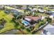 Unique aerial view of a home featuring a refreshing pool, tropical landscaping and canal views at 82 Caddy Rd, Rotonda West, FL 33947