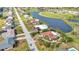 This aerial view captures a single-Gathering home near a golf course and pond, showcasing neighborhood streets at 82 Caddy Rd, Rotonda West, FL 33947