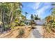 Backyard area featuring decorative greenery, lounge chairs, a canoe, and a white picket fence at 82 Caddy Rd, Rotonda West, FL 33947