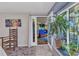 Bright bedroom featuring a beachy painting, doors to the outside and unique wooden rocking chair at 82 Caddy Rd, Rotonda West, FL 33947