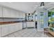 Kitchen features white cabinets, granite counters, stainless appliances, and large windows for natural light at 82 Caddy Rd, Rotonda West, FL 33947