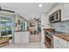 Kitchen with white cabinets, granite countertops, stainless steel appliances, and island with seating at 82 Caddy Rd, Rotonda West, FL 33947