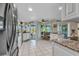 Bright kitchen with white cabinets, granite countertops, tile flooring, stainless appliances, and open layout at 82 Caddy Rd, Rotonda West, FL 33947