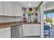 Kitchen featuring stainless dishwasher, granite countertops, white cabinets and a view to outdoor space at 82 Caddy Rd, Rotonda West, FL 33947