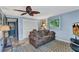 Cozy living room featuring a brown sofa, ceiling fan, and ample natural light through a window at 82 Caddy Rd, Rotonda West, FL 33947