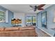 Living room with a flat screen TV, ceiling fan, sliding doors, and a decorative mirror at 82 Caddy Rd, Rotonda West, FL 33947