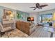 Comfortable living room with a brown leather sofa, ceiling fan, and sliding doors to outdoor area at 82 Caddy Rd, Rotonda West, FL 33947