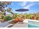 Picturesque poolside retreat with comfortable seating, vibrant landscaping, and stunning water views for ultimate relaxation at 82 Caddy Rd, Rotonda West, FL 33947