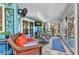 Inviting sunroom with tile floor, comfortable wicker furniture, TV, and bar-style seating, ideal for relaxation and entertaining at 82 Caddy Rd, Rotonda West, FL 33947