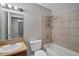 Bathroom featuring vanity with sink, toilet, and shower tub combo with tile surround and shower caddy at 8706 Fish Lake Rd, Tampa, FL 33619