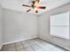 Standard bedroom featuring a ceiling fan, a window, and tile flooring, providing a clean space at 8706 Fish Lake Rd, Tampa, FL 33619
