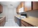 Functional kitchen featuring wood cabinets, a white microwave, and tile flooring at 8706 Fish Lake Rd, Tampa, FL 33619