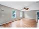 Spacious living room featuring hardwood floors, two windows, and a modern ceiling fan at 8706 Fish Lake Rd, Tampa, FL 33619
