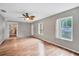 Bright living room with hardwood floors, ceiling fan, and natural light streaming through the windows at 8706 Fish Lake Rd, Tampa, FL 33619