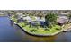 Waterfront home features screened lanai, lush lawn, mature trees, and private dock at 955 Don Juan Ct, Punta Gorda, FL 33950