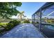 Backyard features a paver patio with a screened-in pool, and tranquil canal views framed by lush landscaping at 955 Don Juan Ct, Punta Gorda, FL 33950