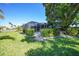 Backyard features a screened-in pool, lush green lawn, and manicured landscaping that borders a tranquil canal at 955 Don Juan Ct, Punta Gorda, FL 33950