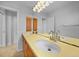 Bright bathroom featuring a double vanity with wooden cabinetry and a large mirror with decorative lighting at 955 Don Juan Ct, Punta Gorda, FL 33950