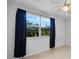 Bedroom featuring a window with dark curtains, allowing natural light to fill the room and highlighting tile flooring at 955 Don Juan Ct, Punta Gorda, FL 33950